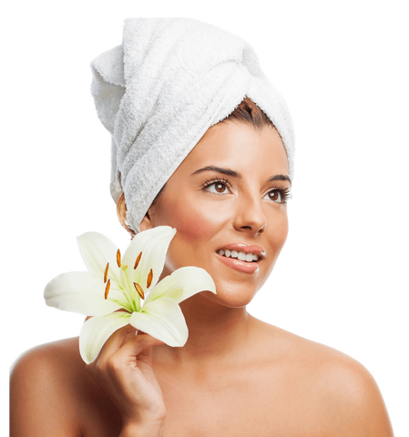 Woman with a towel on her head holding a white lily against a white background  